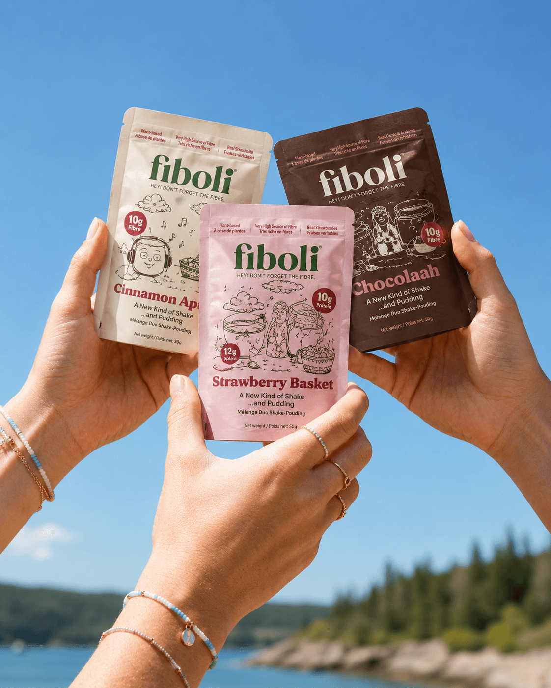 Fiboli snack pouches held up against a bright sky